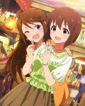  2girls ahoge blue_eyes brown_eyes brown_hair brown_skirt cosmetics green_shirt hagiwara_yukiho holding holding_lipstick_tube idolmaster idolmaster_(classic) idolmaster_million_live! idolmaster_million_live!_theater_days indoors jewelry lipstick_tube multiple_girls official_art one_eye_closed open_mouth shirt skirt surprised tokoro_megumi 