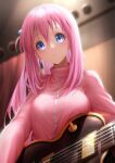  1girl absurdres blue_eyes blurry blurry_background blush bocchi_the_rock! breasts chinese_commentary closed_mouth commentary_request crossed_bangs cube_hair_ornament eyelashes from_below frown glint gotoh_hitori guitar hair_between_eyes hair_ornament hair_over_shoulder highres holding holding_instrument indoors instrument jacket large_breasts long_hair long_sleeves looking_at_viewer looking_down one_side_up pink_hair pink_jacket royboy sidelocks stage tareme track_jacket upper_body wide-eyed 