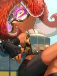  1girl animal_print armor bare_shoulders black_gloves black_shorts breastplate dark-skinned_female dark_skin elbow_gloves fingerless_gloves ganguro gloves goggles green_eyes highres horizontal_pupils leopard_print octoling otoboke-san parted_lips pink_lips redhead shorts sitting solo splatoon_(series) splatoon_3 takozonesu tentacle_hair 