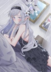  1girl absurdres bare_shoulders bed black_dress black_hairband black_halo blue_archive blush bright_pupils closed_mouth commentary cowboy_shot dress earclip elf flower frilled_dress frills from_side grey_hair grey_halo hair_flower hair_ornament hairband halo heimu_(heim_kstr) highres himari_(blue_archive) indoors long_hair looking_at_viewer looking_to_the_side lying mole mole_under_eye multicolored_halo on_bed on_stomach painting_(object) pointy_ears sleeveless sleeveless_dress smile solo two-tone_halo violet_eyes white_pupils 