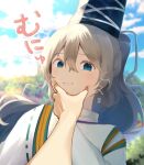  1girl 1other absurdres black_hat blue_eyes blue_sky blurry blurry_background closed_mouth clouds commentary_request grey_hair hair_between_eyes hat highres japanese_clothes kariginu long_sleeves looking_at_viewer medium_hair meme mononobe_no_futo moriya210 nejime outdoors ponytail pov pov_cheek_grabbing_(meme) ribbon-trimmed_sleeves ribbon_trim sky solo tate_eboshi touhou upper_body wide_sleeves 