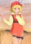  1girl adapted_costume aki_minoriko bare_legs blonde_hair closed_mouth commentary_request cowboy_shot frilled_hoodie happy hat highres hood hood_down hoodie mizune_(winter) mob_cap mountainous_horizon orange_eyes orange_hat orange_hoodie outdoors short_hair smile solo touhou yellow_hoodie 