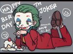  1boy animification batman_(series) cake dated dc_comics facepaint food food_on_face fork full_body green_eyes green_hair hair_slicked_back happy_birthday highres holding holding_fork jacket joker_(2019) joker_(dc) long_hair long_sleeves lying male_focus moesaku6 on_stomach pants ringed_eyes smile smiley_face solo suit tongue tongue_out 