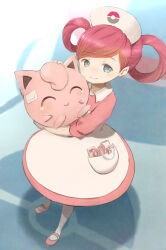 1girl amekana apron apron_pocket bandaid bandaid_on_face blue_eyes blush closed_eyes closed_mouth commentary_request dress eyelashes full_body hair_rings hat highres holding holding_pokemon jigglypuff joy_(pokemon) notepad nurse nurse_cap pink_dress pink_hair pink_shoes poke_ball_symbol pokemon pokemon_(creature) pokemon_xy scissors shoes smile standing tears twintails white_apron white_hat