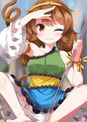  1girl blue_dress blurry blush bo_staff breasts brown_hair circlet closed_mouth collarbone commentary depth_of_field detached_sleeves dress gold_circlet green_dress highres long_hair looking_at_viewer low_twintails medium_breasts monkey_girl monkey_tail multicolored_dress red_eyes ruu_(tksymkw) ruyi_jingu_bang single-shoulder_dress single_detached_sleeve smile solo son_biten tail touhou twintails yellow_dress 