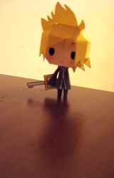  1boy artist_request black_coat_(kingdom_hearts) black_pants blonde_hair blurry chibi chinese_commentary commentary_request depth_of_field english_commentary expressionless full-length_zipper full_body holding holding_weapon illbewaiting keyblade kingdom_hearts kingdom_hearts_ii long_sleeves male_focus mixed-language_commentary on_table pants papercraft_(medium) photo_(medium) roxas short_hair solid_oval_eyes solo spiky_hair table unconventional_media weapon wide_sleeves yellow_background zipper 