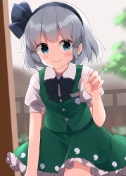  1girl black_bow black_bowtie black_hairband blue_eyes blush bow bowtie closed_mouth collared_shirt commentary_request frilled_skirt frills green_skirt green_vest grey_hair hairband highres hitodama_print konpaku_youmu looking_at_viewer medium_hair puffy_short_sleeves puffy_sleeves ruu_(tksymkw) shirt short_sleeves skirt skirt_set smile solo sweat touhou tree vest white_shirt 