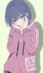  1girl blue_eyes blue_hair blush bob_cut closed_mouth clothes_writing commentary_request dot_nose drawstring drop_shadow green_background hands_on_own_cheeks hands_on_own_face hands_up head_tilt highres hood hood_down hoodie ka2ya_aaa kiritani_haruka long_sleeves looking_at_viewer pink_hoodie project_sekai raised_inner_eyebrows short_hair sidelocks simple_background solo upper_body 