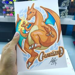  art_tools_in_frame artist's_hand_in_frame character_name charizard claws closed_mouth commentary dragon english_commentary fire flame-tipped_tail looking_at_viewer marker_(medium) photo_(medium) pokemon pokemon_(creature) signature stanley_lau tail traditional_media 