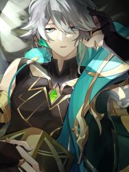  1boy absurdres akademiya_uniform alhaitham_(genshin_impact) asymmetrical_sidelocks black_gloves black_shirt book cable cape chest_jewel commentary_request compression_shirt feather_hair_ornament feathers gem genshin_impact gloves gold_trim green_cape green_eyes green_gem grey_hair hair_between_eyes hair_ornament hair_over_one_eye highres holding holding_book jewelry looking_at_viewer male_focus multicolored_hair on_bed partially_fingerless_gloves raimu_(raimuo_illust) shirt short_hair side_cape sidelocks 