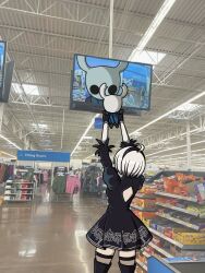  1girl 1other 2b_(nier:automata) ahoge arms_up back_cutout black_dress black_gloves black_hair camera_feed carrying clothing_cutout commentary crossover dress empty_eyes english_commentary fake_horns gloves helmet highres hollow_knight horned_helmet horns knight_(hollow_knight) meme nier:automata nier_(series) photo_background puffy_sleeves short_hair showing_baby_to_a_supermarket_camera_(meme) standing television white_hair yuffie_drawings 