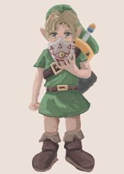  1boy belt blonde_hair boots brown_background brown_boots commentary full_body green_hat green_tunic hat highres holding holding_mask last_night_story link looking_at_viewer male_focus mask mask_of_truth pointy_ears shield simple_background solo standing sword the_legend_of_zelda the_legend_of_zelda:_majora's_mask tunic weapon 
