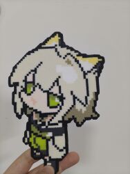  1girl absurdres arknights artist's_hand_in_frame cat_girl chinese_commentary coat commentary_request deformed dress full_body green_dress green_eyes green_hair highres kal'tsit_(arknights) lab_coat looking_at_viewer open_clothes open_coat perler_beads_(medium) photo_(medium) solo unconventional_media yiyuan1231 