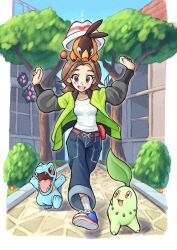  1girl bell-bottoms belt blue_sky breasts brown_eyes brown_hair chikorita commentary fangs green_jacket grimmelsdathird harmony_(pokemon) hat highres jacket leaf long_sleeves lumiose_city on_head open_clothes open_jacket open_mouth outdoors pants pokemon pokemon_(creature) pokemon_legends:_z-a pokemon_on_head prism_tower red_eyes ribbed_socks sharp_teeth shirt shoes short_hair sky smile socks starter_pokemon_trio striped_hat symbol-only_commentary teeth tepig totodile tree white_hat white_shirt 