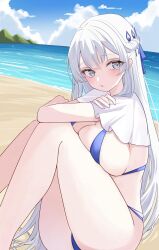  1girl argus_(azur_lane) argus_(dignified_swimsuit_training)_(azur_lane) azur_lane beach bikini blue_bikini blue_eyes braid breasts clouds commentary_request crossed_arms crown_braid dreamoon highres long_hair mountain ocean official_alternate_costume pale_skin sand sitting sky solo swimsuit thighs white_hair 
