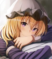  1girl blonde_hair blush closed_mouth commentary dress fumei_(mugendai) hat long_hair long_sleeves looking_at_viewer lying maribel_hearn mob_cap on_stomach purple_dress sleeve_cuffs sleeve_garter smile solo touhou violet_eyes white_hat 