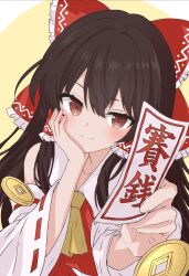 1girl absurdres ascot blush bow brown_eyes brown_hair closed_mouth coin commentary detached_sleeves frilled_bow frilled_hair_tubes frills hair_bow hair_tubes hakurei_reimu hand_on_own_cheek hand_on_own_face highres holding holding_ofuda holed_coin long_hair ofuda red_bow red_skirt reoreo0716 ribbon-trimmed_sleeves ribbon_trim skirt skirt_set smile solo touhou translation_request untranslatable_commentary yellow_ascot 