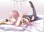  1girl bed belt black_legwear cable hand_to_mouth headphones holding legs long_hair lying megurine_luka on_stomach pink_hair retsuna smile solo thighhighs vocaloid wire 