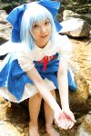  1girl asian barefoot blue_hair bow cirno cosplay dress feet lenfried looking_at_viewer looking_up mole photo rock solo touhou water wig wings 